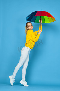 带伞的女孩摄影照片_身穿黄色毛衣、带五彩伞的女人摆出彩虹色