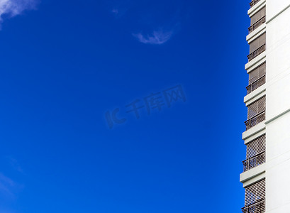 蓝色高楼大厦背景摄影照片_高楼大厦和明亮的蓝天