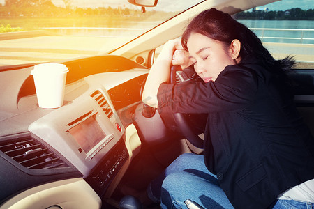 疲惫的年轻女人睡在她的车里