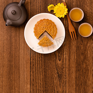 中中秋节摄影照片_深色木桌上的茶月饼，中秋节传统食品布局设计的节日概念，顶视图，平躺，复制空间。