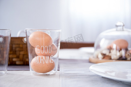文字早上好摄影照片_玻璃里的鸡蛋，厨房的桌子上写着早上好文字