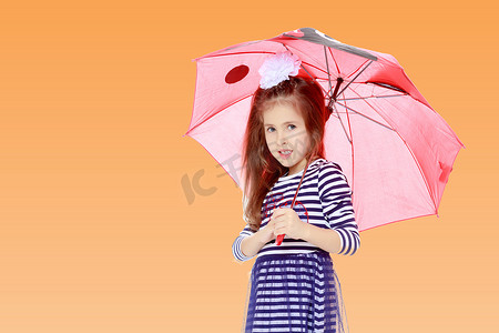 大雨伞摄影照片_躲在雨伞下的小女孩。