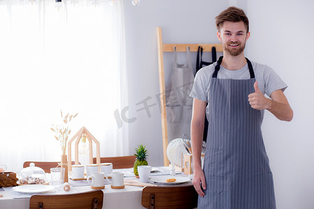 一位微笑的男厨师的肖像在 Kitc 打手势访问标志