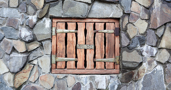 在老石谷仓墙壁的小木装货门。