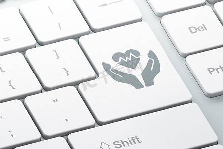 线上合同摄影照片_保险概念：电脑键盘背景上的心脏和手掌