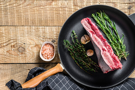 新鲜的生牛肉排骨肉在平底锅上加香草。