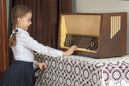 旧收音机摄影照片_小女孩听旧收音机。