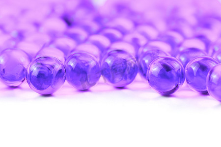 胶囊紫色摄影照片_白色背景上具有选择性聚焦的质子紫色球形胶囊