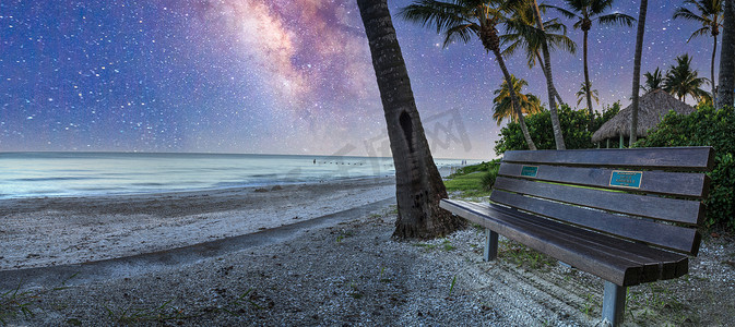 星辰大海摄影照片_长凳上的银河俯瞰着皇家港海滩的大海