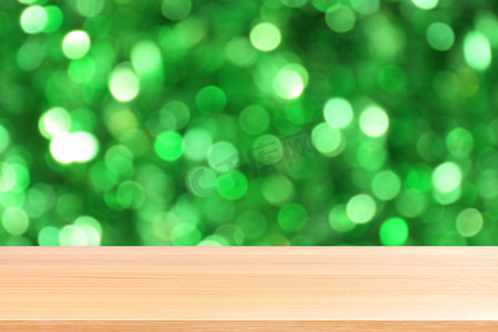 新店开业空前钜惠摄影照片_木板照明美丽闪闪发光的绿色散景背景，空木桌地板在阳光下照明绿色自然森林散景，木桌板空前绿色闪光背景灯