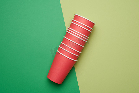 绿色背景上的一叠红纸一次性杯子，平l