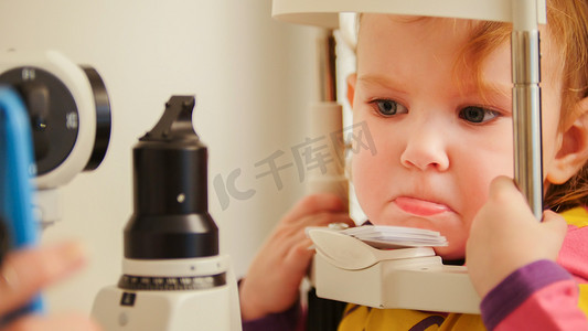 儿童验光概念 — 眼科诊所检查视力时生气的小女孩