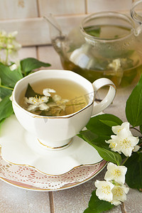 茉莉花茶与白色木桌背景上的茉莉花。