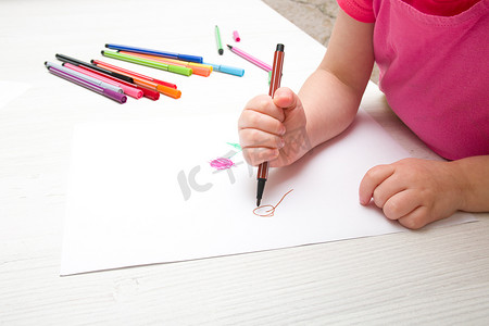 小女孩用毡尖笔在纸上画花，放在桌子上，儿童发展