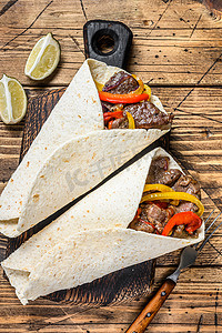 Fajitas 玉米饼包裹着牛肉肉条、彩色甜椒、洋葱和莎莎酱。