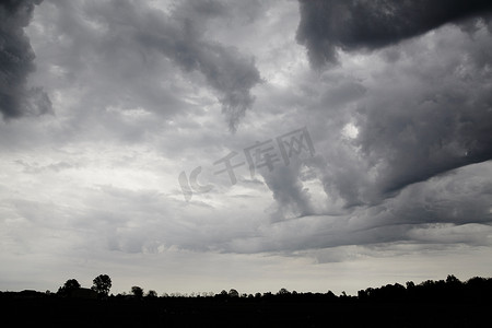 云纹古典祥云图案摄影照片_背景是黑色地平线的卷曲不祥云的黑白照片