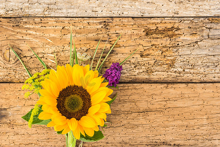 感恩母亲节摄影照片_乡村木头上的一束黄色向日葵花
