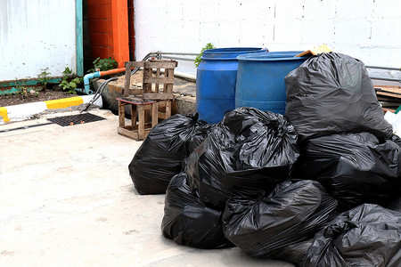 黑色垃圾塑料袋摄影照片_垃圾是一堆垃圾堆，走道社区村的许多垃圾塑料袋黑色垃圾，垃圾塑料垃圾的污染，塑料垃圾袋，垃圾堆，很多垃圾场