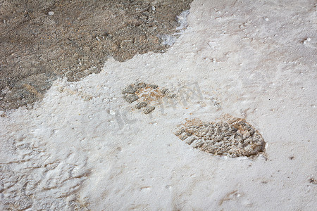 单脚印摄影照片_施工现场湿混凝土上的单靴足迹