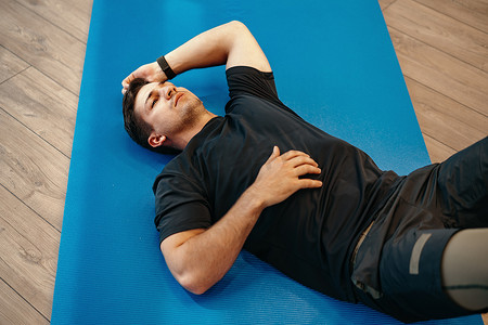 年轻肌肉发达的白种帅哥在垫子上做腹肌锻炼