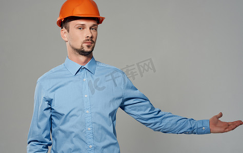 灰色背景肖像上身着橙色油漆和蓝色衬衫的男建筑师