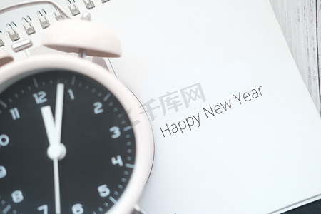 时钟一月摄影照片_日历上的新年快乐文本，桌上有时钟