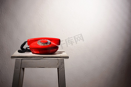 凳子上的摄影照片_白色凳子上的红色老式电话