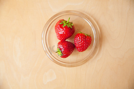 木制背景中玻璃碗中的草莓