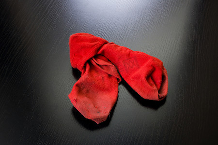 在一张木桌上的肮脏的红色袜子