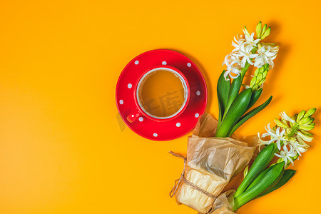 白色风信子旁边的白色点缀杯茶中的红色