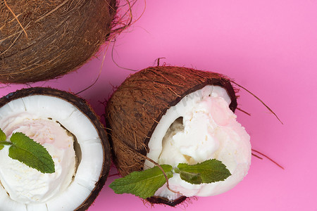 新鲜椰子半香草冰淇淋球，粉红色背景上装饰着薄荷叶
