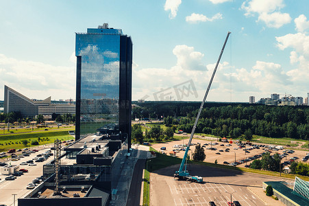 从最高的汽车起重机的高度看，它在城市玻璃建筑附近的停车场开放，准备工作。