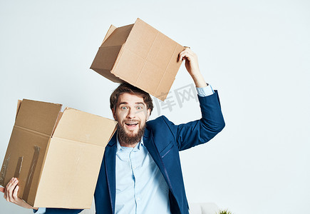 搬家公司头像摄影照片_一个拿着箱子的男人，而一套西装正在搬家拆包