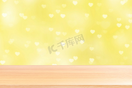 散景灯上的空木桌地板心形柔和黄色背景，木桌板空前散景心形多彩，木板空白在多彩散景闪耀心形柔和黄色