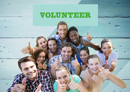 志愿者的背景摄影照片_木质背景下快乐的志愿者群体