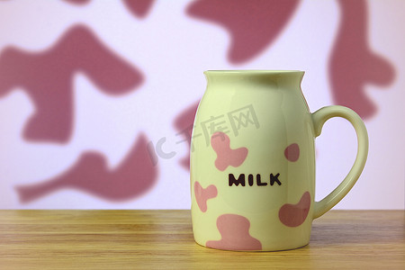 桌上的粉色和白色图案牛奶杯