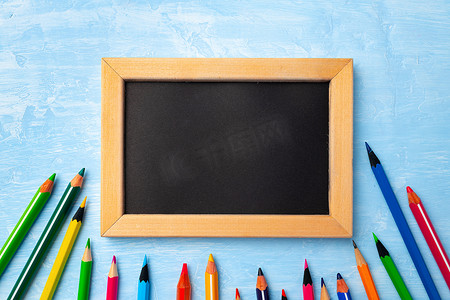 木制框架中的小黑板被彩色铅笔包围
