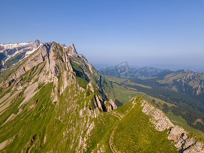 策摄影照片_Schaefler Altenalptuerme 山脊瑞士 Alpstein 高山 Appenzell Innerrhoden 瑞士，瑞士阿彭策尔 Alpstein 山脉雄伟的 Schaefler 峰的陡峭山脊，雾覆盖着 Seealpsee 山谷