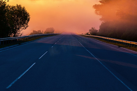 夏季高速公路附近有护栏的世界清晨浓雾