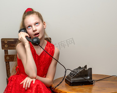 响摄影照片_一个小女孩正在用那部旧电话铃响。