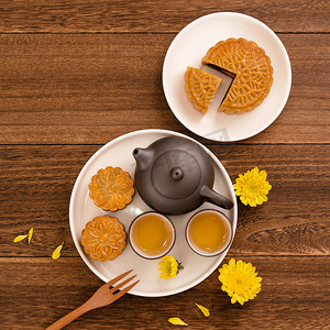 中月饼摄影照片_深色木桌上的茶月饼，中秋节传统食品布局设计的节日概念，顶视图，平躺，复制空间。