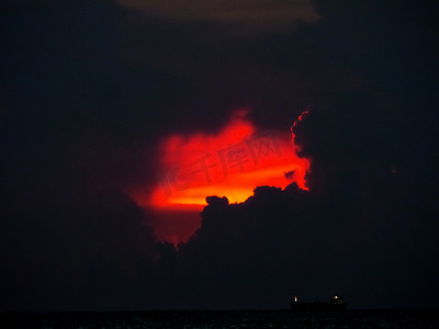 海上黑暗天空中夕阳红云的最后一道光