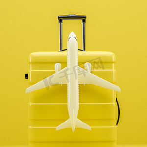 旅行箱背景摄影照片_黄色旅行箱上的一架白色飞机。 