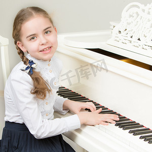一个音乐学校的女孩弹钢琴。