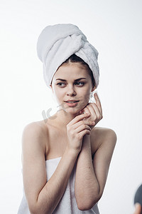 护肤摄影照片_淋浴后的女人头上戴着毛巾摆出护肤姿势