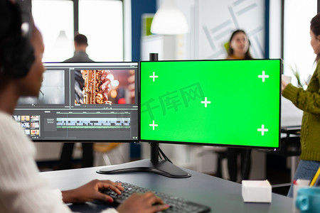 带有耳机的非洲视频编辑器使用带绿屏的 PC 编辑素材