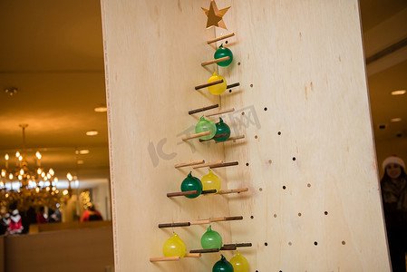 几何雕塑圣诞树与绿色和黄色的灯泡。