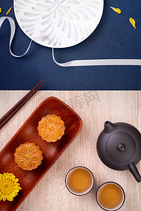 月饼上摄影照片_创意月饼月饼设计灵感，在中秋节享受月亮，在木桌概念、顶视图、平躺上享用糕点和茶