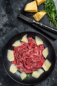 牛肉沙拉摄影照片_生牛肉片沙拉配大理石花纹牛肉、芝麻菜和巴马干酪。