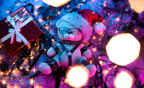 一只戴着圣诞老人帽子的熊是新年霓虹灯下的性用品商店为 BDSM 游戏准备的圣诞礼物